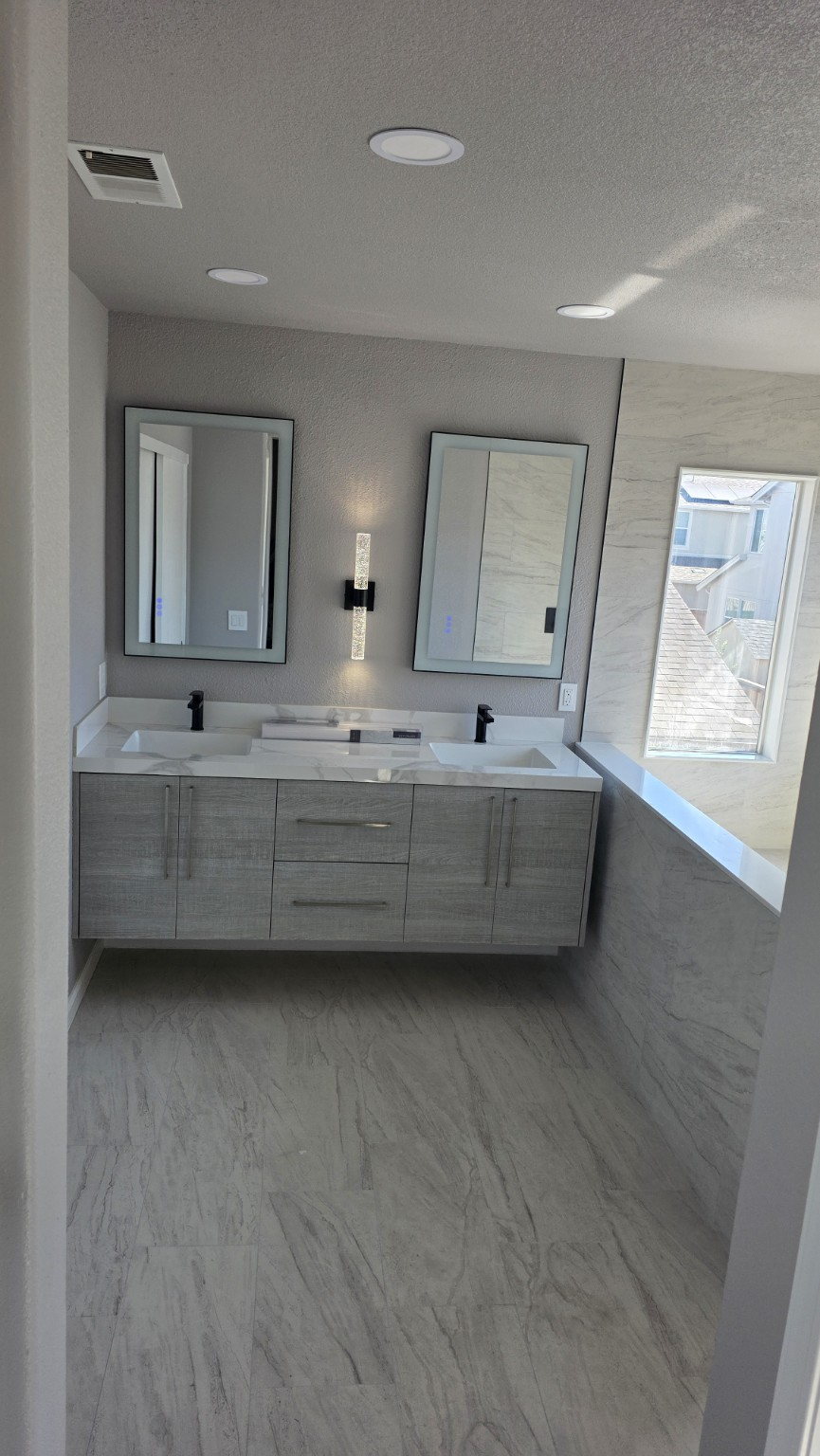 Renovated bathroom with double vanity and tiled shower